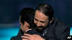 ARCHIVO - El dominicano Juan Luis Guerra, derecha, felicita al puertorriqueño Marc Anthony durante la celebración de los premios Billboard Latinos 2010 en San Juan, Puerto Rico. (AP)