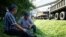 Truck drivers rest in the shade in front of the Bogdanka coal mine while they wait for coal to be loaded, in Bogdanka, Poland, Aug. 26, 2022. 