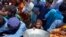 Displaced families line up to receive food as they take refuge on a roadside after fleeing their flood-hit homes in Sohbat Pur city, a district of Pakistan's southwestern Baluchistan province, Aug. 30, 2022.