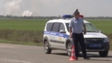 In this image taken from video provided by the RU-RTR Russian television on Aug. 16, 2022, a policeman blocks a way to the site of explosion at an ammunition storage of Russian army near the village of Mayskoye, Crimea.