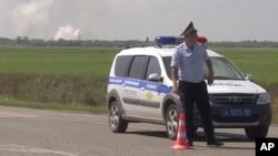 Policajac blokira put koji vodi ka skladištu municije ruske vojske koje je eksplodiralo, nedaleko od sela Majskoje, Krim.