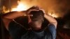 FILE - A man looks at a forest fire near Larbaa Nath Irathen, 100 kilometers east of Algiers, Aug. 11, 2021. At least 26 people died in forest fires that ravaged 14 districts of northern Algeria Aug. 17, 2022. the nation's interior minister said.