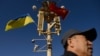 FILE - A man passes under a lamp post displaying Ukrainian and Chinese flags on Tiananmen Square in Beijing, China, Dec. 5, 2013. While Ukrainian President Volodymyr Zelenskyy has said that China has shown “neutrality” in his country's conflict with Russia, others beg to differ.