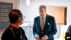 FILE - Paul Pelosi, right, the husband of House Speaker Nancy Pelosi of California, walks through Capitol Hill in Washington, March 17, 2022. 