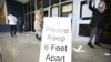 FILE - A sign asks those getting vaccinated to keep 6 feet apart during the vaccination event, at Nevada Union High School in Grass Valley, California, Jan. 27, 2021. 