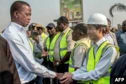 FILE - Zambia's then- President Edgar Lungu, left, meets and greets Chinese workers from Aviation Industry Corporation of China in Lusaka, Zambia, Sept. 15, 2018. China has been playing a role in restructuring the external debt of some African countries such as Zambia.