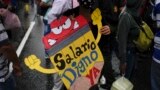 Una maestra protesta con un cartel que pide mejores salarios, en Caracas, Venezuela, el 10 de agosto de 2022. Foto AP.
