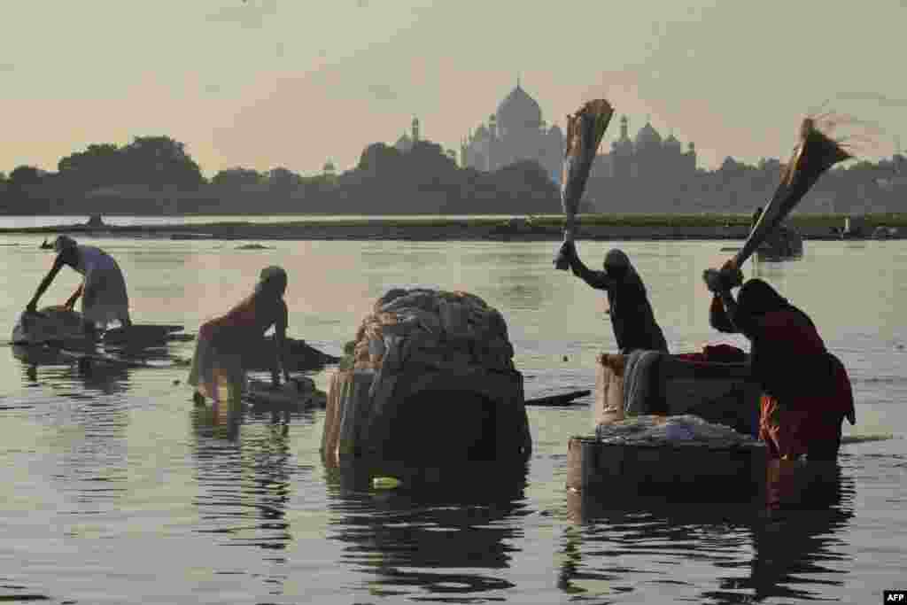 Orang-orang mencuci pakaian di Hathi Ghat di sepanjang Sungai Yamuna dengan latar belakang Taj Mahal di kota Agra, India. (Foto: AFP)&nbsp;