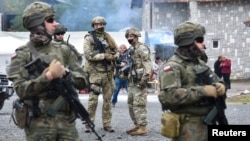 FILE - Members of the KFOR peacekeeping force patrol the area near the border crossing between Kosovo and Serbia in Jarinje, Kosovo, Oct. 2, 2021.