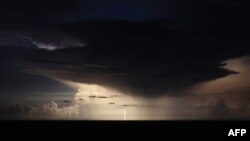 A photograph taken from the French Riviera city of Nice shows lightning flashes in a supercell thunderstorm over the Mediterranean sea on the night of August 18 to 19.