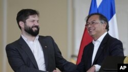 El presidente de Chile, Gabriel Boric, a la izquierda, le da la mano a su par de Colombia, Gustavo Petro, al comienzo de una conferencia de prensa en el palacio presidencial de Bogotá, Colombia, el lunes 8 de agosto de 2022. (AP Foto/Fernando Vergara)