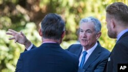 Federal Reserve Chair Jerome Powell, center, takes a coffee break with attendees of the central bank's annual symposium at Jackson Lake Lodge in Grand Teton National Park, Aug. 26, 2022. in Moran, Wyoming.