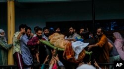 Warga desa membawa mayat Sunil Kumar, seorang pria Hindu Kashmir yang dikenal sebagai Pandit, di luar rumahnya di desa Chotigam, selatan Srinagar, Kashmir-India, Selasa, 16 Agustus 2022. Pandit ditembak mati oleh tersangka pemberontak di sebuah kebun apel hari Selasa pagi.