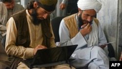Taliban member Gul Agha Jalali (L) attends a computer science class at the Ministry of Transport and Civil Aviation in Kabul, Afghanistan, June 5, 2022. 