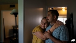 Ana Sandoval, madre de Eyvin Hernandez, un abogado de Los Ángeles detenido desde hace cinco meses en Venezuela, se abraza de su hijo Henry Martinez, medio hermano de Hernandez, mientras posan para una foto en Compton, California, el 29 de agosto de 
