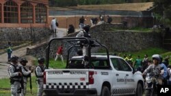 Elementos de la Guardia Nacional custodian el lugar donde se produjo un enfrentamiento entre grupos de delincuentes, que dejó varios policías heridos y más de una decena de personas detenidas, en Tupilejo, Ciudad de México, el martes 12 de julio. 2022.