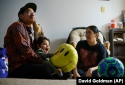 Georgianna Garbow-Warren and Randy Warren Sr., sit with their son, Randy, Jr., in their Moorhead, Minn., apartment, Wed., Nov. 17, 2021.