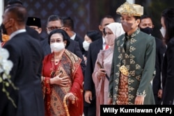 Presiden Joko Widodo (kanan), istrinya Iriana Widodo (tengah) dan mantan presiden Megawati Sukarnoputri (kedua dari kiri) meninggalkan parlemen setelah menyampaikan pidato tahunan di Jakarta pada 16 Agustus 2022, menjelang perayaan Hari Kemerdekaan. (Foto