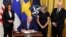 Predsednik SAD Džo Bajden potpisuje Protokol o pristupanju Švedske i Finske NATO-u, u društvu potpredsednice Kamale Haris, švedske ambasadorke Karin Olofsdoter i finskog ambasadora Mika Hautale, 9. avgust 2002. 