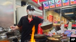 A worker wears a face mask to protect against the spread of the coronavirus at a night market in Taipei, Taiwan, Aug. 29, 2022.