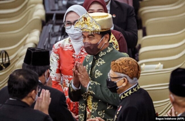 Presiden Joko Widodo (tengah) menyapa anggota parlemen sebelum menyampaikan pidato tahunannya di parlemen di Jakarta pada 16 Agustus 2022, menjelang perayaan Hari Kemerdekaan. (Foto: AFP/BAGUS INDAHONO)