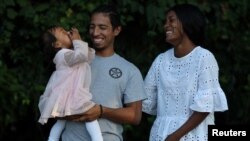 Noralis Zúñiga, Juan Camilo Mendoza y su hija Evangeline, de 1 año, posan para un retrato en Washington, EEUU, el 23 de agosto de 2022.