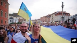 People take part in a rally observing Ukraine's Independence Day and the six-month mark of the Russian invasion of Ukraine in Warsaw, Poland, Aug. 24, 2022.
