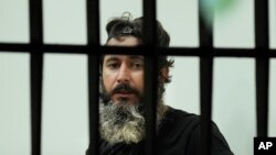 Bassam al-Sheikh Hussein (42), melihat melalui jendela bank, di Beirut, Lebanon, Kamis, 11 Agustus 2022. (AP/Hussein Malla)