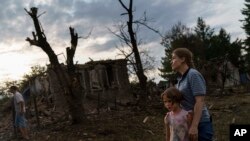 Los residentes observan las casas dañadas durante un ataque con cohetes en Kramatorsk, en el este de Ucrania, a primeras horas del 16 de agosto, mientras las fuerzas rusas continúan bombardeando la provincia de Donetsk, dijeron funcionarios regionales.