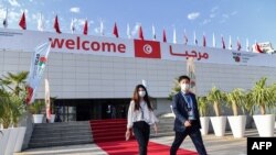 Attendees walk outside the Congress Palace, hosting the eighth Tokyo International Conference on African Development (TICAD), in Tunisia's capital, Tunis, on Aug. 27, 2022.