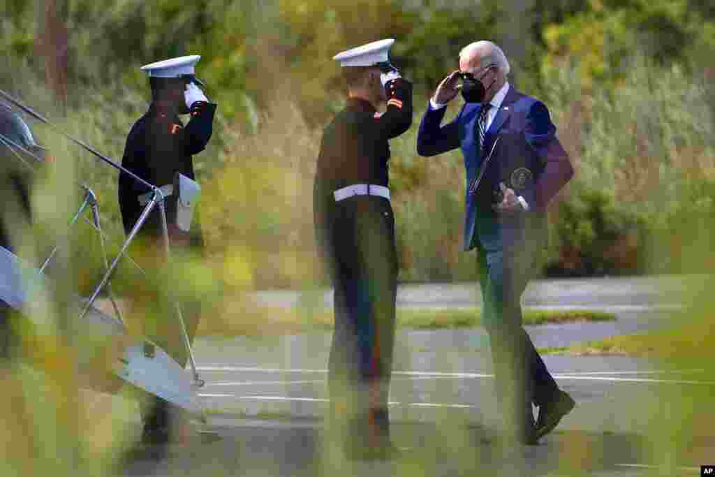 American President Joe Biden returns a salute as he walks to board Marine One at Gordons Pond State Park in Rehoboth Beach, Delaware, to travel back to the White House.