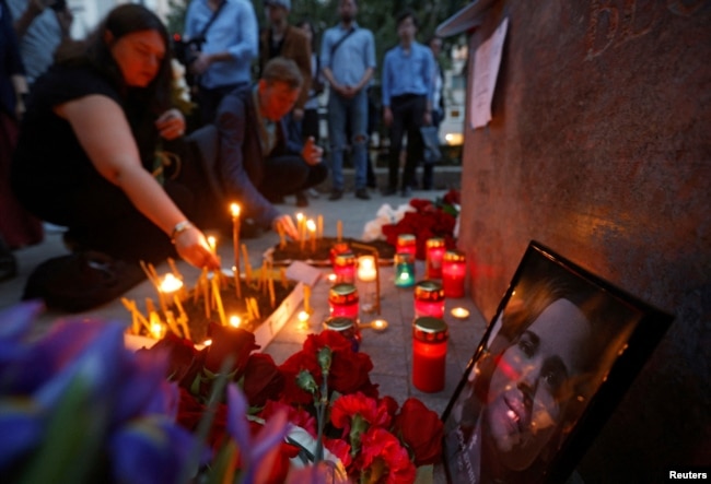 Flowers and candles are placed next to a portrait of media commentator Darya Dugina, who was killed in a car bomb attack, in Moscow, Russia August 22, 2022. (REUTERS/Maxim Shemetov)