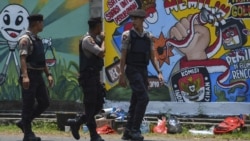 FILE - Polisi berjalan di depan mural kampanye Pemilu 2019 di Banda Aceh, 17 Maret 2019. (CHAIDEER MAHYUDDIN/AFP)