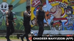 FILE - Polisi berjalan di depan mural kampanye Pemilu 2019 di Banda Aceh, 17 Maret 2019. (CHAIDEER MAHYUDDIN/AFP)