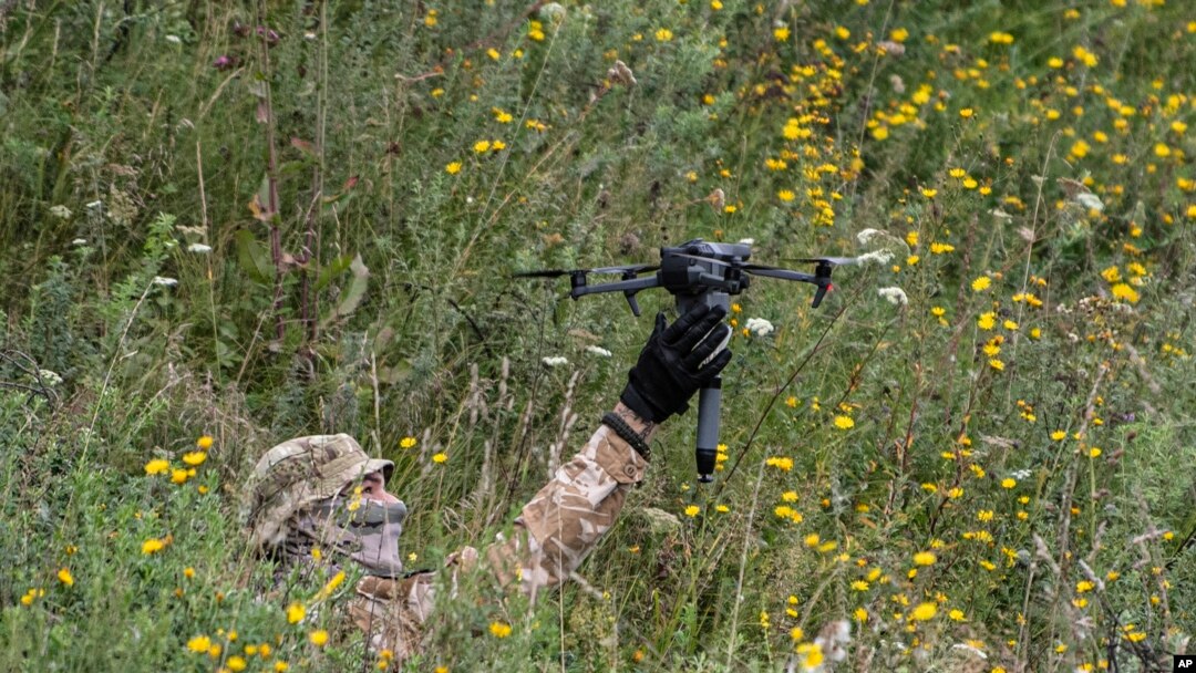 A volunteer soldier holds up a drone used for explosives at a training area near Kyiv, Ukraine, Aug. 27, 2022. Fighters from Chechnya are aiding both sides of the conflict in Ukraine.