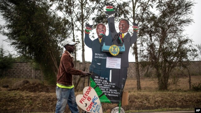 A supporter of Kenya's President-elect William Ruto pushes a cart with cardboard cutout of the president and his running mate, outside the official residence of the deputy president in the Karen area of Nairobi, Kenya Aug. 17, 2022.