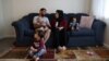 The Mohammadi family, Najib holding Yusuf, Yasar, Susan and Zahra, sit together in their living room, at their home in Sacramento, California, Aug. 1, 2022.