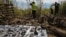 Ukrainian forensic police officers look for shrapnel as they examine a crater following a missile strike in the Dokuchaievske village near Kharkiv, Aug. 21, 2022. 