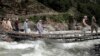 Sejumlah warga tampak menyeberangi sungai melalui jembatan yang rusak akibat banjir yang melanda Kota Bahrain, Pakistan, pada 30 Agustus 2022. (Foto: AP/Naveed Ali)