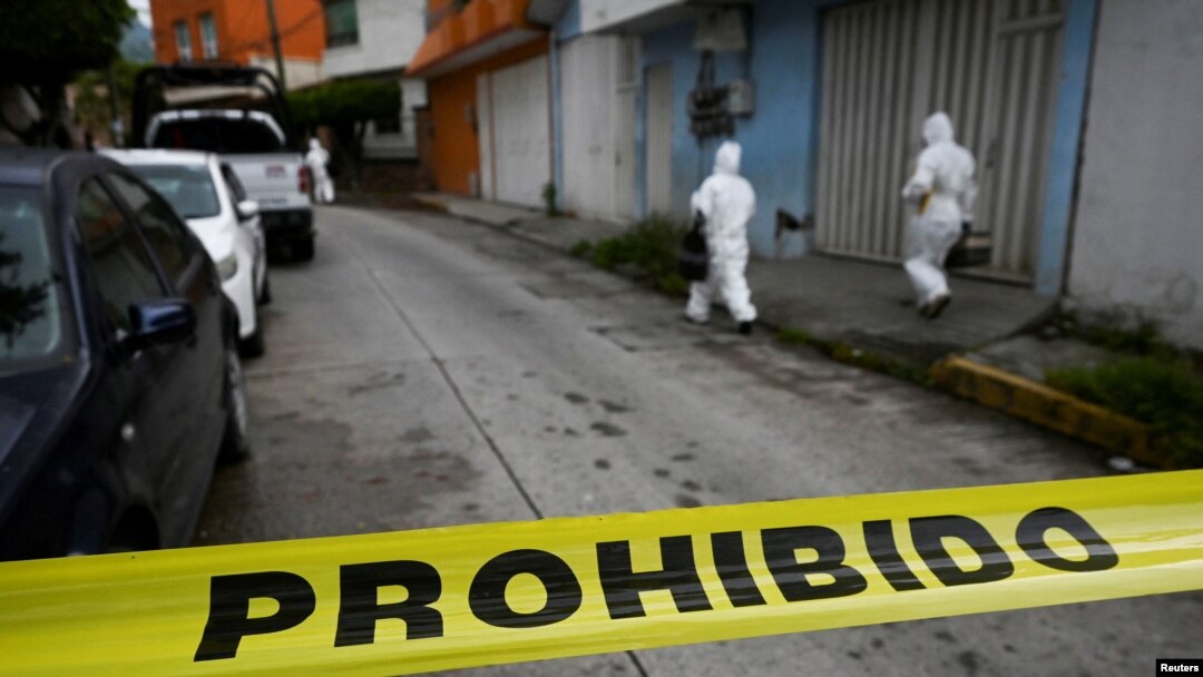 Anggota tim forensik berjalan di dekat TKP di mana jurnalis Fredid Roman tewas di mobilnya oleh penyerang bersenjata yang mengendari sepeda motor di Chilpancingo, negara bagian Guerrero, Meksiko 22 Agustus 2022. (REUTERS/Lenin Ocampo Torres) 