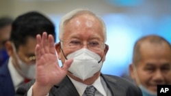 FILE - Former Malaysian Prime Minister Najib Razak, center, wearing a face mask arrives at Court of Appeal in Putrajaya, Malaysia, Aug. 16, 2022. 