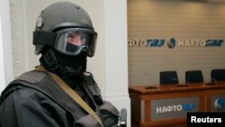 FILE - An armed man stands in the headquarters of Ukraine's state energy firm Naftogaz in Kiev, March 4, 2009.