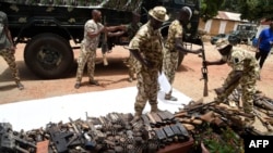 FILE - Nigerian soldiers take inventory on April 21, 2022, of small arms and light weapons recovered from bandits during an operation in north central Nigeria. 