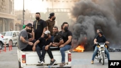Supporters of Iraqi Shiite cleric Muqtada al-Sadr gather on a road blocked with burning tires during a demonstration in Iraq's southern city of Basra, Aug. 29, 2022. 