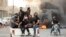 Supporters of Iraqi Shiite cleric Muqtada al-Sadr gather on a road blocked with burning tires during a demonstration in Iraq's southern city of Basra, Aug. 29, 2022. 