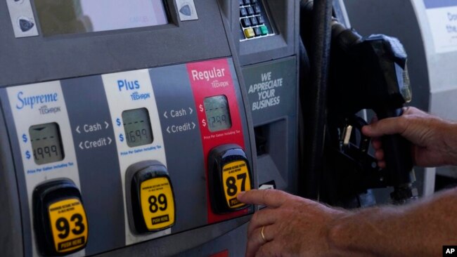 FILE - A customer pumps gas at an Exxon gas station, May 10, 2022, in Miami.