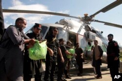 Polisi perbatasan memuat makanan ke helikopter untuk membantu orang-orang yang terkena dampak banjir, di lembah Swat, Pakistan, Minggu, 28 Agustus 2022. (Foto: AP)