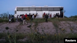 Migrantes que buscan asilo ingresan a un autobús de la Patrulla Fronteriza de EEUU tras cruzar el río Grande desde México, el 26 de julio de 2022.