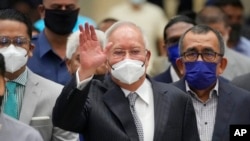 Mantan Perdana Menteri Malaysia Najib Razak (tengah), mengenakan masker, melambaikan tangan setibanya di Pengadilan Banding di Putrajaya, Malaysia, Selasa, 23 Agustus 2022. (AP/Vincent Thian)