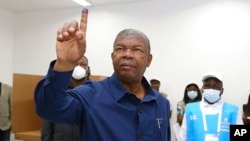 Le président angolais Joao Lourenço montre son doigt marqué lors du processus de vote dans un bureau de vote à Luanda, en Angola, le 24 août 2022.